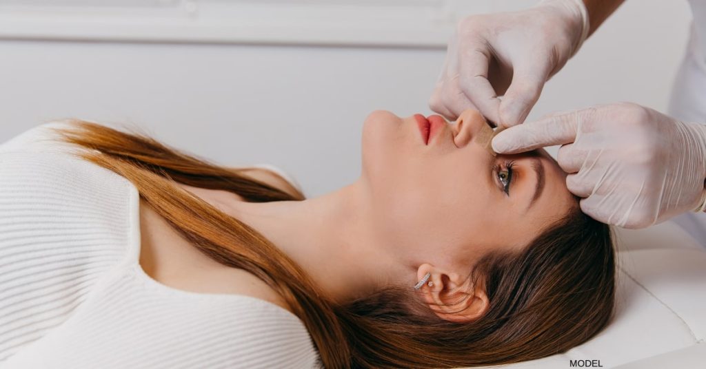 Woman (model) preparing for rhinoplasty at a consultation.