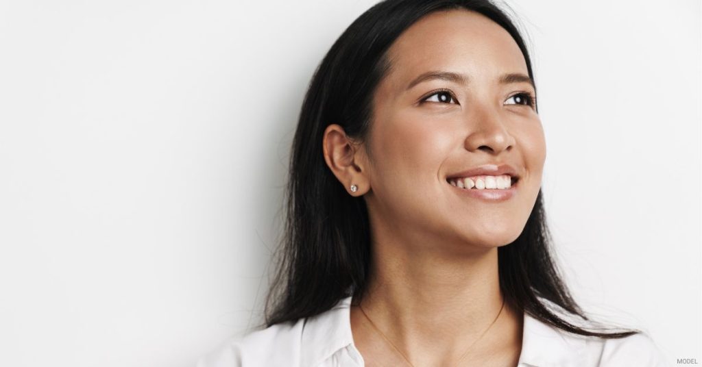 Asian woman (model) smilling with open eyes.